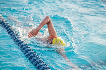 Person doing freestyle stroke in a swimming pool lane