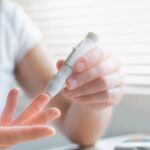 Woman measuring her blood sugar to test for reactive hypoglycemia